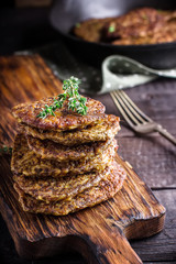 Flat cutlets on chopping board. Dark wooden background.