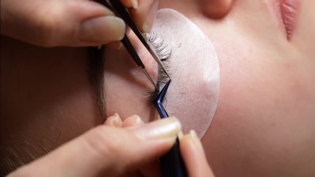 young girl on the procedure of eyelash beauty salon