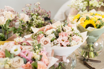 Bouquets on table, florist business. Different varieties fresh spring flowers. Delivery service. Flower shop concept.
