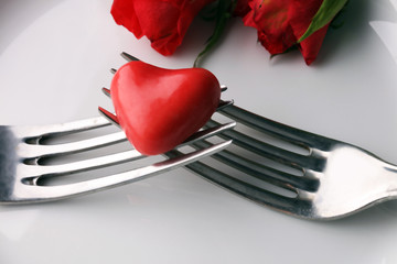 Festive table setting for Valentine's Day with fork, knife and rose