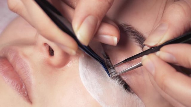 young girl on the procedure of eyelash beauty salon