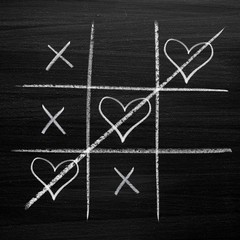 Tic tac toe game with chalk hearts, XO noughts and crosses Valentine's Day style