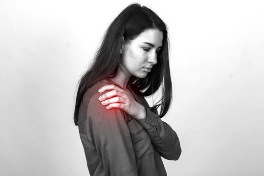 Young woman with shoulder pain. Black and white with a red accent
