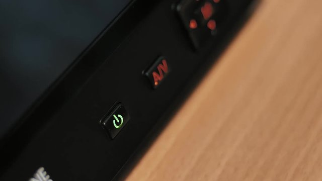 Turning power on and off on monitor with illuminated buttons.