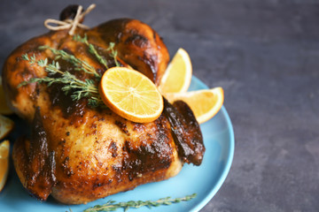 Delicious whole roasted chicken with orange served on plate