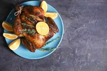 Delicious whole roasted chicken with orange served on plate
