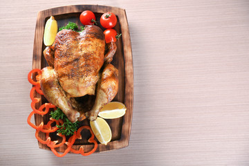 Delicious whole roasted chicken with vegetables served on wooden board
