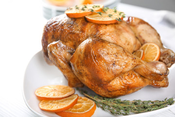 Delicious whole roasted chicken with orange served on plate