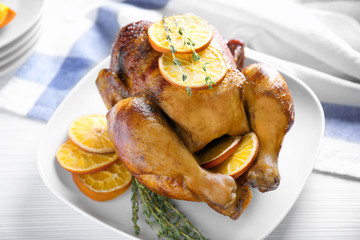 Delicious whole roasted chicken with orange served on plate