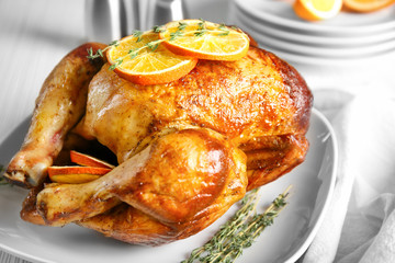 Delicious whole roasted chicken with orange served on plate