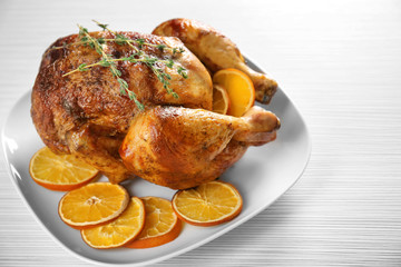 Delicious whole roasted chicken with orange served on plate