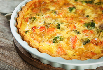 Baking dish with tasty broccoli quiche on table, closeup