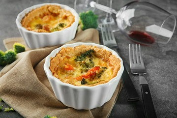 Ramekins with tasty broccoli quiche on table