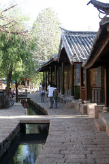 couple walking down the sidewalk with guys arm over girl in shuhe ancient town , China