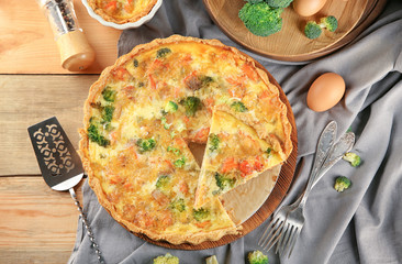 Tasty broccoli quiche on wooden board