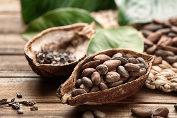Ripe cocoa pod with beans on wooden background