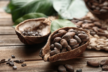 Ripe cocoa pod with beans on wooden background
