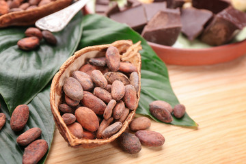 Half of cocoa pod with beans on wooden table