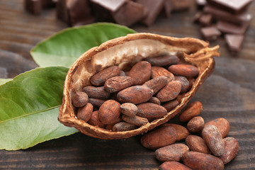 Half of cocoa pod with beans on wooden table