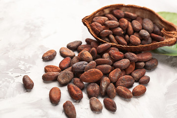 Half of cocoa pod with beans on light background