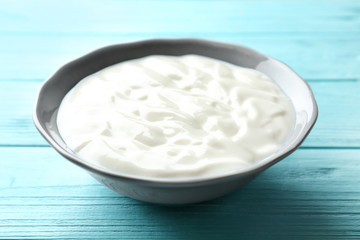 Tasty yogurt in dish on wooden table