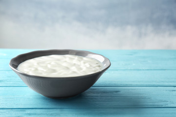 Tasty yogurt in dish on wooden table