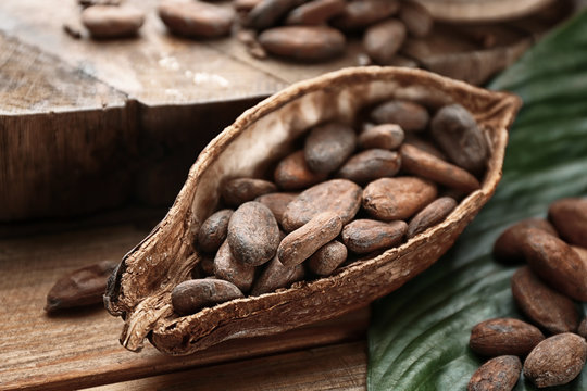 Ripe cocoa pod with beans on wooden background