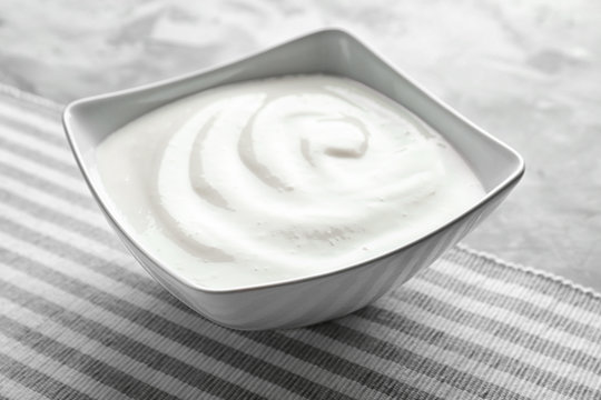 Tasty yogurt in dish on table