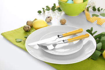 Beautiful festive Easter table setting with eggs on white background, closeup