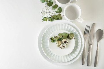 Beautiful festive Easter table setting with quail eggs on white background