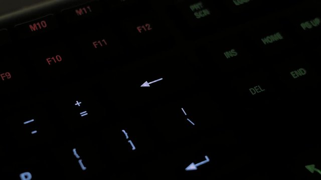 Man pressing backspace or delete key on modern illuminated computer keyboard.