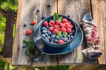 Sweet raspberries and blueberries on old wooden rustic table