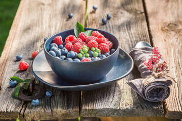 Tasty raspberries and blueberries on old wooden rustic table