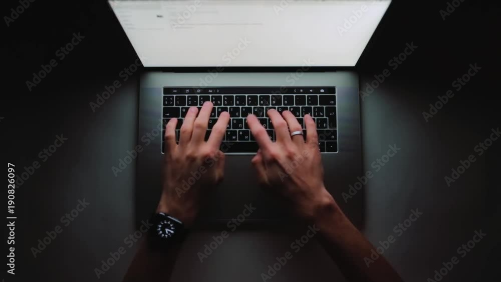 Aufkleber man is working typing use laptop computer at home office at dark. writer flat lay top view workplace