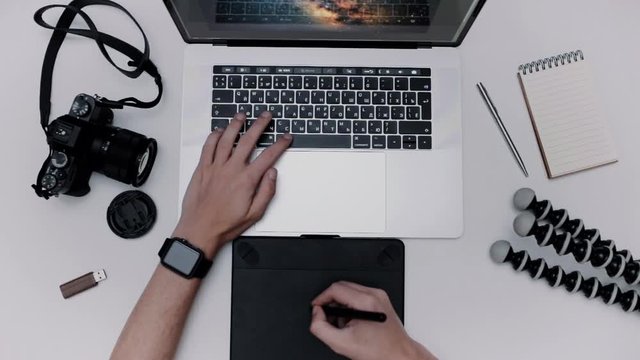 Man is working laptop computer and graphic tablet. Designer flat lay top view workplace
