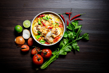 Top view of oxtail soup,Traditional muslim food with cow tail boiled with Spices,fresh ingredients and herbs on dark brown wooden texture floor, halal food,Selective focus