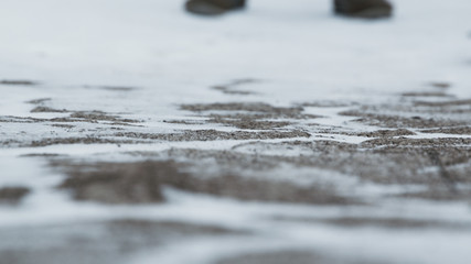 Close-up of male legs in winter shoes walking on snow. Footage, View of walking on snow with Snow shoes and Shoe spikes in winter. Men's legs in boots close up the snow-covered path