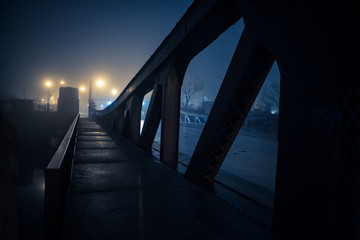 Dramatic industrial vintage river bridge scenery at night with illuminating fog in Chicago.