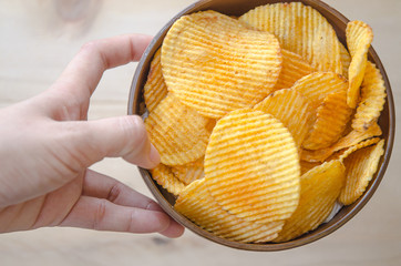 Crispy potato chips In the brown cup in the Asian women's hand