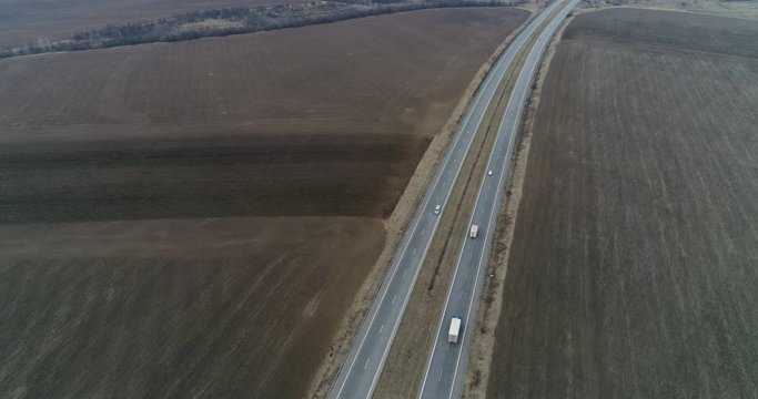 Drone shot of car driving on a highway on a dull day