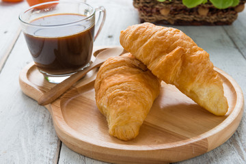 Tasty croissants on white wood background
