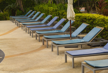 Relaxing chairs beside of swimming pool in hotel