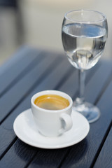 White cup of coffee and glass of water place on wood table