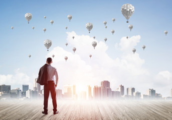 Motivation and inspiration concept with modern cityscape and businessman observing it