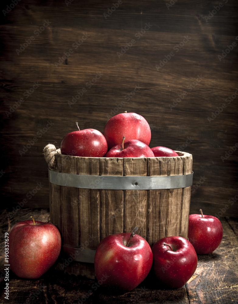 Sticker Red ripe apples in a wooden bucket.