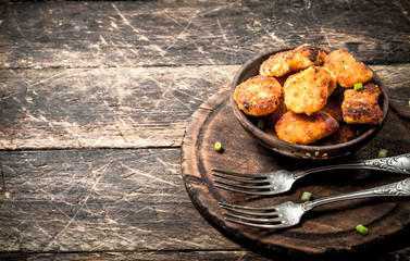 Chicken nuggets in a bowl with forks.