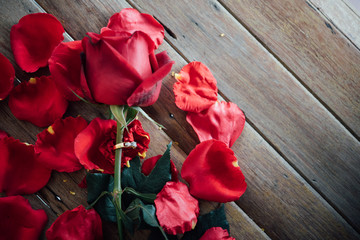 Naklejka na ściany i meble Red rose flower on wooden floor in Valentine's Day