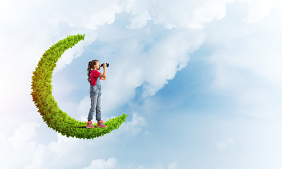 Concept of careless happy childhood with girl on green moon
