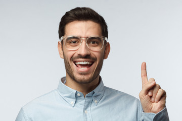 I have an idea! Handsome business man keeping finger pointed upwards, showing something above his head, making gesture with index finger. Eureka, solution sign concept
