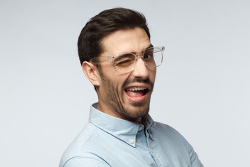 Handsome man smiling and winking, looking at camera